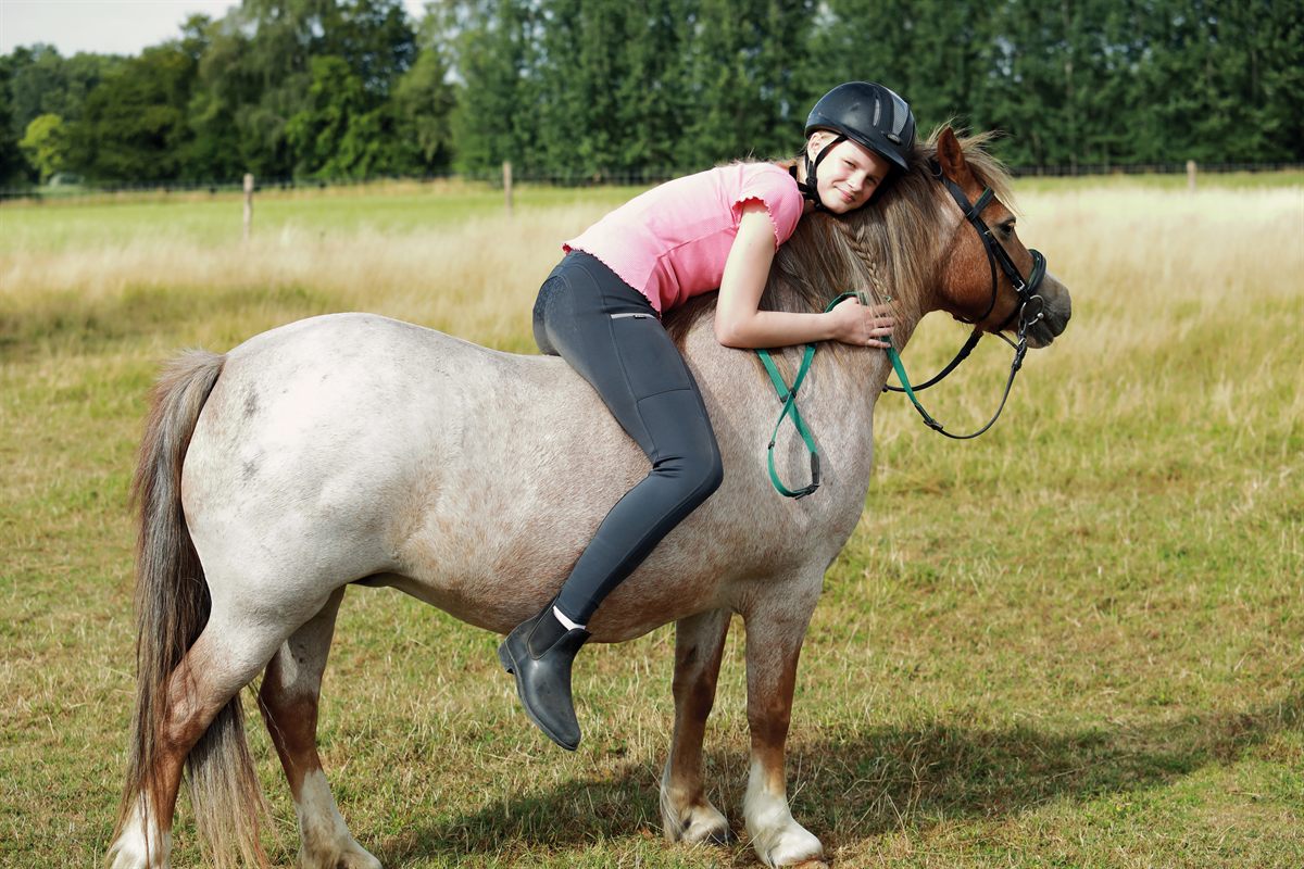 Kind kuschelt mit einem Pony