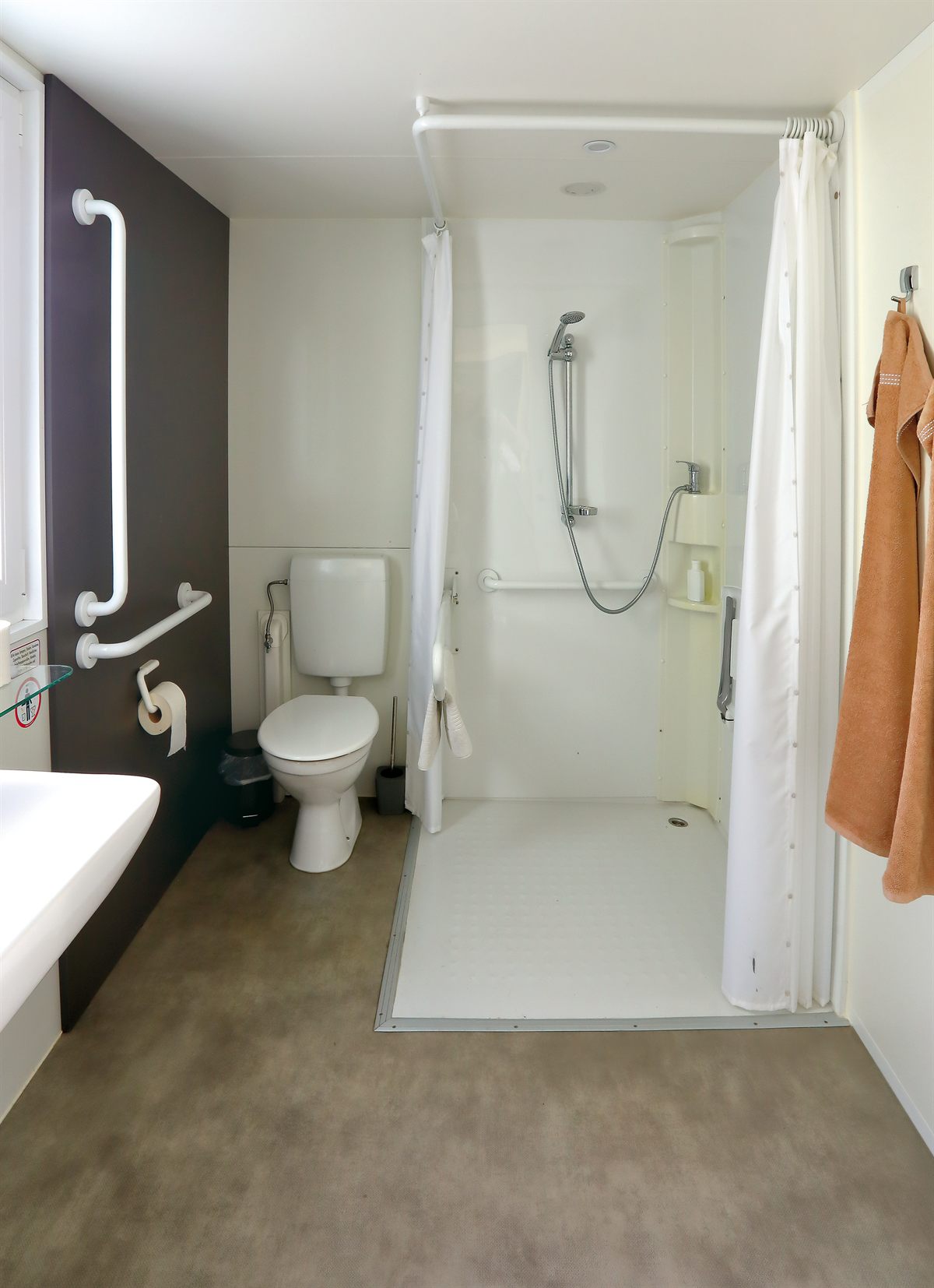 Barrierefreies Badezimmer mit ebenerdiger Dusche und Haltegriffen