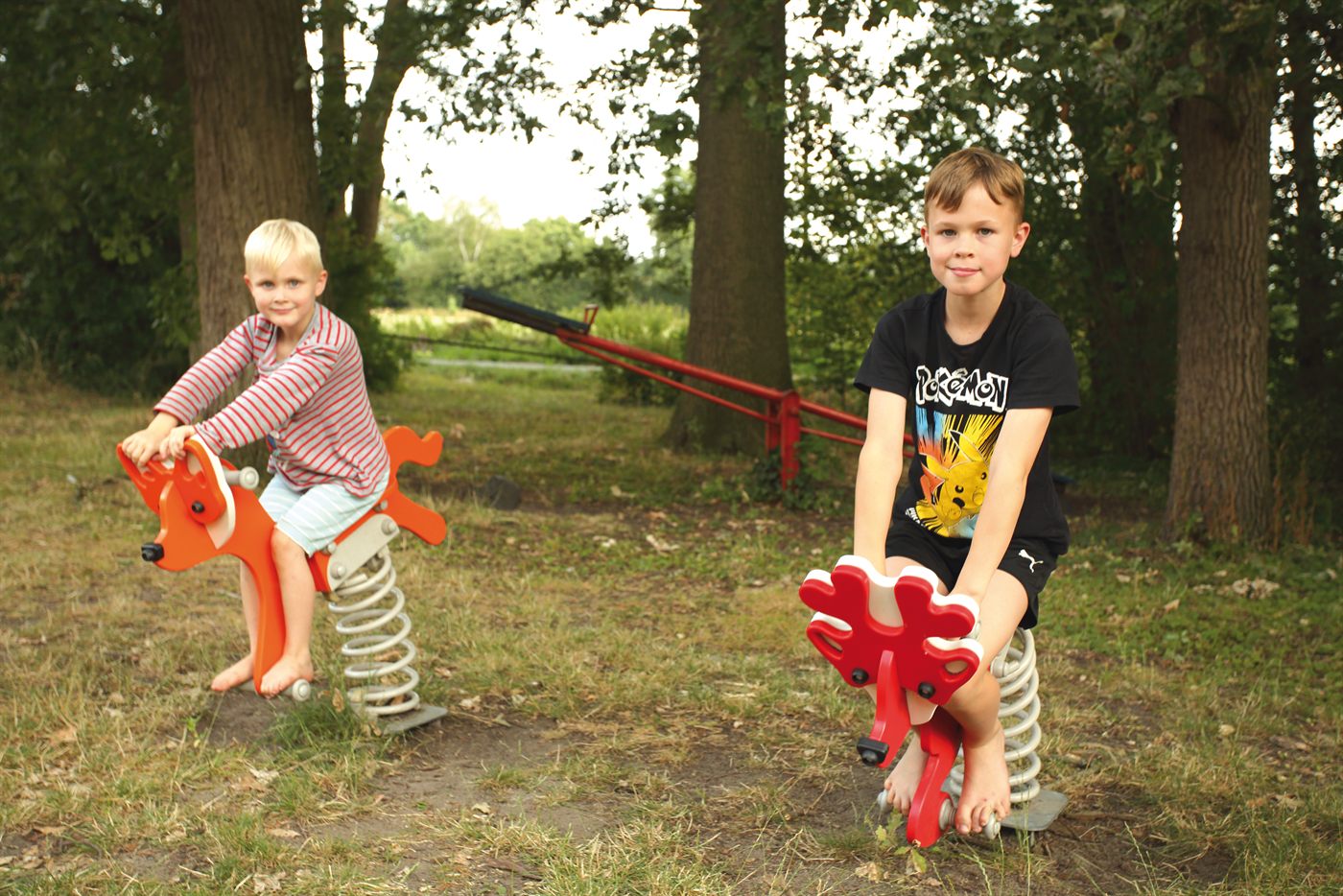 Kinder auf dem Spielplatz mit Federwippen
